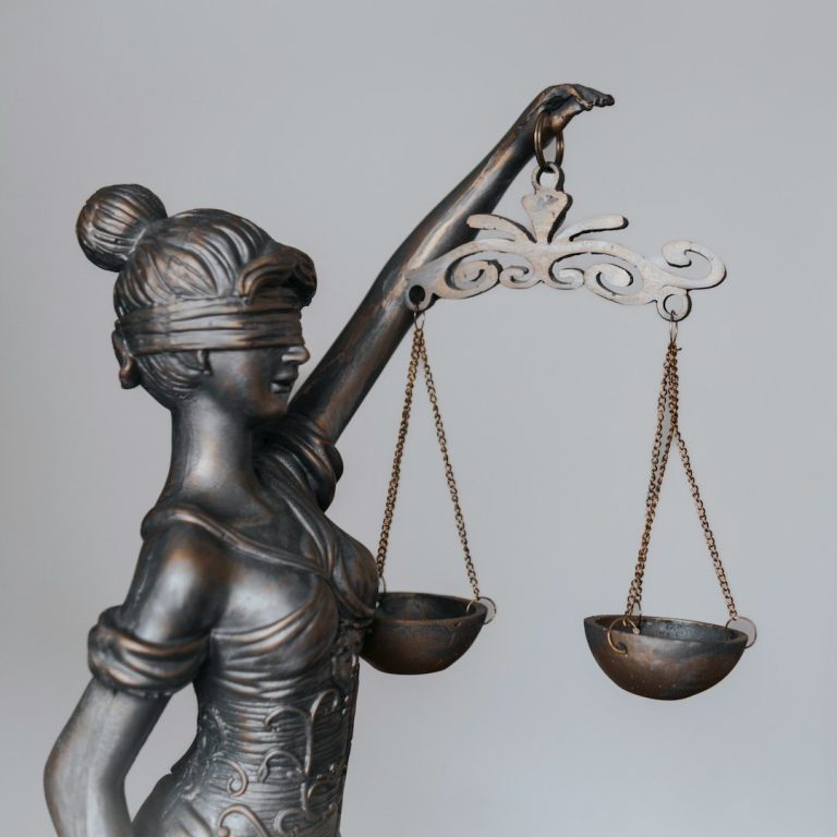 Éthique professionnelle : respect du cadre légal et des règles déontologiques chez VILA’GENCIS Statue de la justice aux yeux bandés tenant une balance, symbole du respect de la loi et de la déontologie
